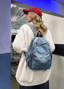 Détail du sac à dos en jean bleu clair avec poches zippées pour l'école et le voyage