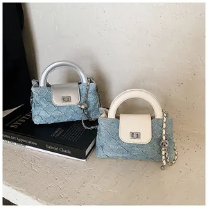 Detail von Mini-Denim-Beuteltaschen mit silberner Metallkette und schicken Tragegriffen
