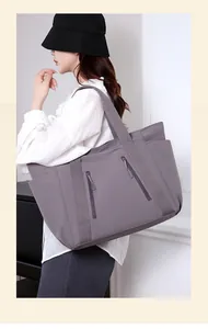 Vista laterale di una borsa tote in nylon grigio-viola indossata da una modella