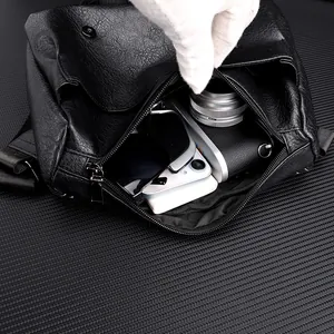 Macro detail of PU leather messenger bag interior holding a camera and smartphone