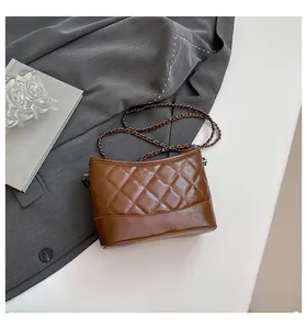 Close-up of brown quilted leather bag with elegant metal chain strap and stitching detail