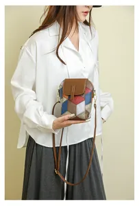Detail der bunten geometrischen Crossbody-Handytasche aus Leder an einem Modell