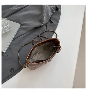 Top view of quilted brown leather bucket bag with chain strap and spacious interior
