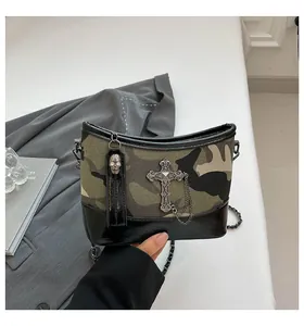 Detail of camouflage chain bag with vintage cross emblem and glossy patent leather base