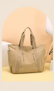 Dettaglio borsa tote in nylon kaki con cinghie rinforzate e tasche laterali esterne