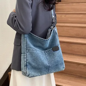 Large washed denim tote bag in retro blue with adjustable strap and leather logo patch