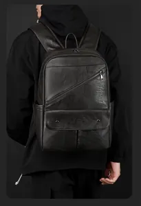 Detail of black leather backpack featuring multiple front pockets and sleek texture