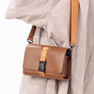 Brown leather crossbody box bag for men with adjustable shoulder strap and buckle
