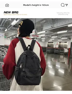 Vue portée d'un sac à dos en denim noir délavé avec bretelles rembourrées au style décontracté