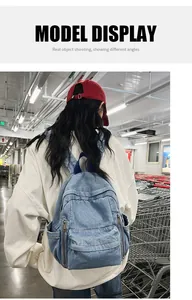Gros plan du sac à dos en denim bleu clair avec sangles bleu foncé et poche à fermeture