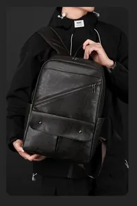 Close-up of the black leather backpack featuring multiple pockets and natural grain texture