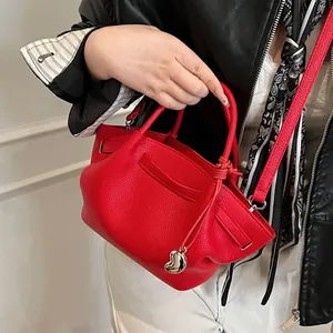 Red lychee grain leather wing tote bag with silver heart pendant and crossbody strap