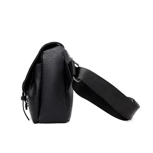 Detail of waterproof black PU leather messenger bag with textured finish and wide strap