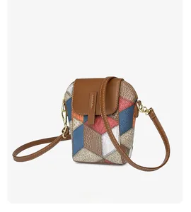 Detail der Crossbody-Handytasche mit geometrischem Patchwork und goldenen Metallhaken
