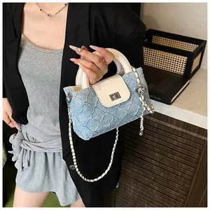 Details der Eimer-Tasche aus blauem Denim und beigem Leder mit silbernem Drehverschluss