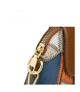 Detailaufnahme des goldenen Reißverschlusses und der Beschläge einer Patchwork-Handtasche