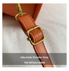 Detail of adjustable orange leather strap with vintage brass metal hardware buckle