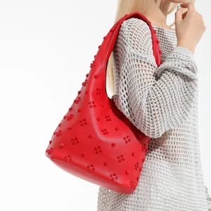 Red hobo shoulder bag with clover-shaped rivet studs and lychee pattern leather