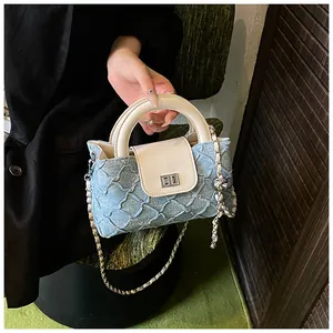 Detail der hellblauen Denim-Beuteltasche mit silbernem Verschluss und Kettenriemen