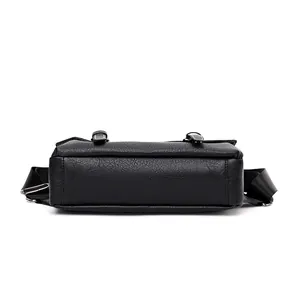 Detailed bottom view of black PU leather messenger bag with textured finish and strap