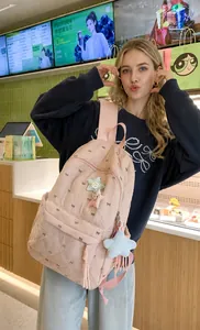 Pink quilted backpack featuring black bow patterns and soft plush star charms