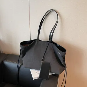 Minimalist black canvas tote bag with drawstring detail and matching small pouch