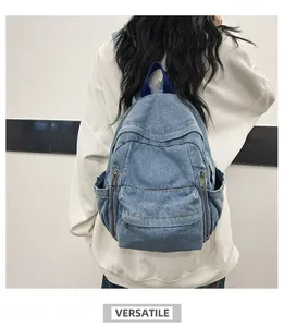 Vue arrière d'un sac à dos en denim délavé avec poches zippées sur un mannequin blanc