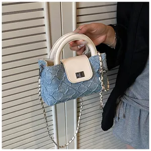 Details der hellblauen Denim-Beuteltasche mit Plissee-Struktur und silbernem Metallverschluss