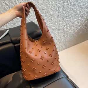 Retro tan leather underarm bag with vintage rivets and textured lychee grain finish