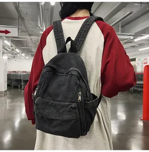 Détail du sac à dos en denim gris foncé avec poche à rabat porté par un mannequin