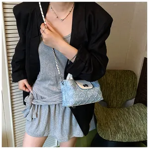 Detailansicht hellblaue Denim-Beuteltasche mit weißer Klappe und silberner Kette
