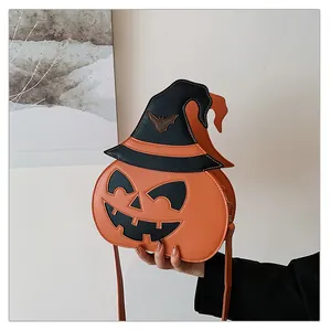 Detail of orange pumpkin crossbody bag with wizard hat and bat charm for Halloween