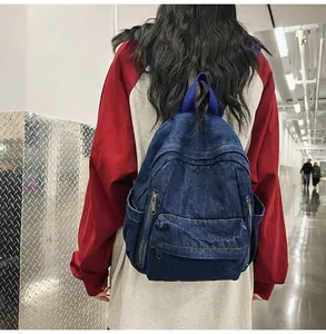 Détail d'un sac à dos en jean avec fermetures éclair métalliques et poignée tissée