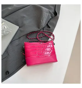 Macro shot of glossy rose pink crocodile pattern texture and woven chain strap details