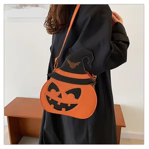 Detail of pumpkin crossbody bag with wizard hat shown on a black coat outfit
