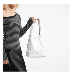 Close-up of white shoulder bag featuring unique 3D floral and dotted textured details