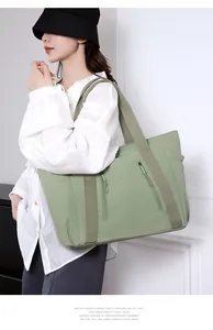 Dettaglio della borsa tote verde in nylon impermeabile con tasche a zip e tracolla larga