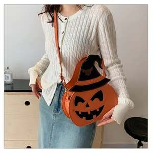 Detail of pumpkin-shaped crossbody bag with wizard hat and bat embroidery detail