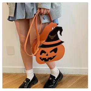 Detail of pumpkin crossbody bag with a black wizard hat and gold bat pattern accents