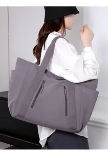 Dettaglio della borsa tote in nylon impermeabile con doppie tasche a zip e tracolla larga