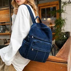 Vista lateral de una mochila vintage de mezclilla azul oscuro con dos bolsillos frontales