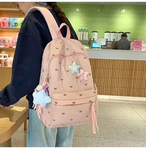Detailed close-up of quilted pink backpack with black bow prints and star patches