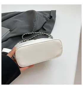 Detail view of the quilted leather base and chain strap of this white hobo bag