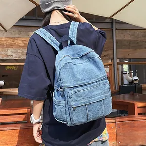 Detalle de la mochila de mezclilla lavada azul con correas anchas y bolsillos laterales