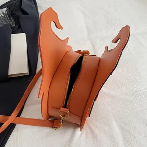 Unique orange pumpkin shoulder bag with bat wings on minimalist white background