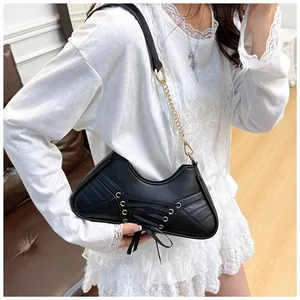 Detail of black ballet-style shoulder bag with corset lacing and metal eyelets on soft leather