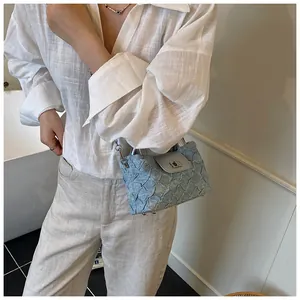 Detailaufnahme der hellblauen gesteppten Beuteltasche mit silbernem Drehverschluss und Kette
