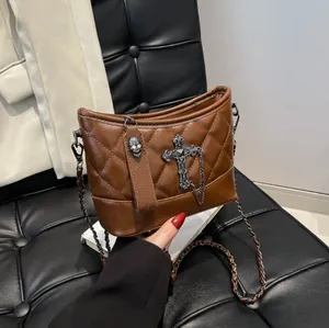 Brown quilted crossbody bag with Gothic silver cross and skull charms and chain strap