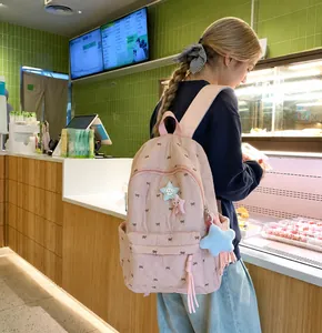 Detailed side view of pink quilted backpack with bow embroidery and star-shaped charms