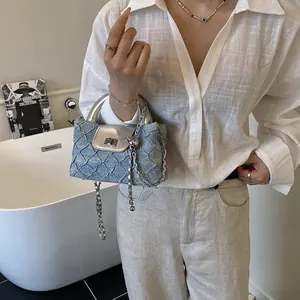 Gesteppte hellblaue Beuteltasche mit silberner Kette und modernen Metallakzenten